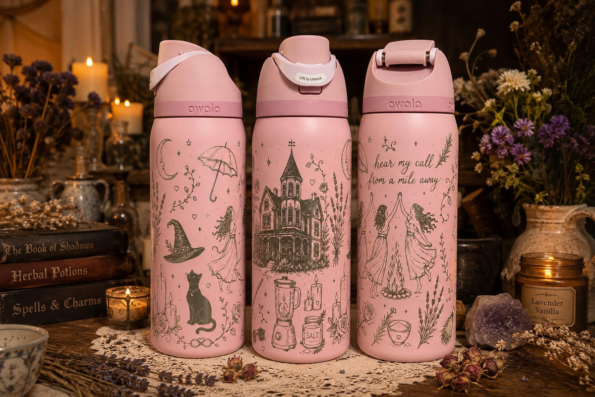 May include: Three light pink Owala water bottles featuring dark gray line art illustrations. The designs include a witch hat, a cat, a house, candles, and figures dancing around a fire with the text "hear my call from a mile away."