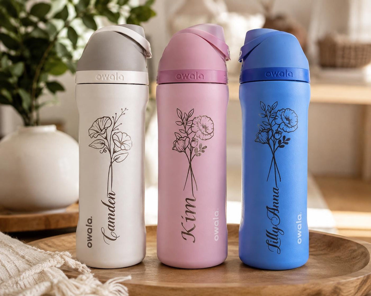 May include: Three Owala water bottles in white, pink, and blue, each featuring a black floral line art design and a personalized name in script font. The bottles have a matching colored lid with a carry loop and the Owala brand name printed.